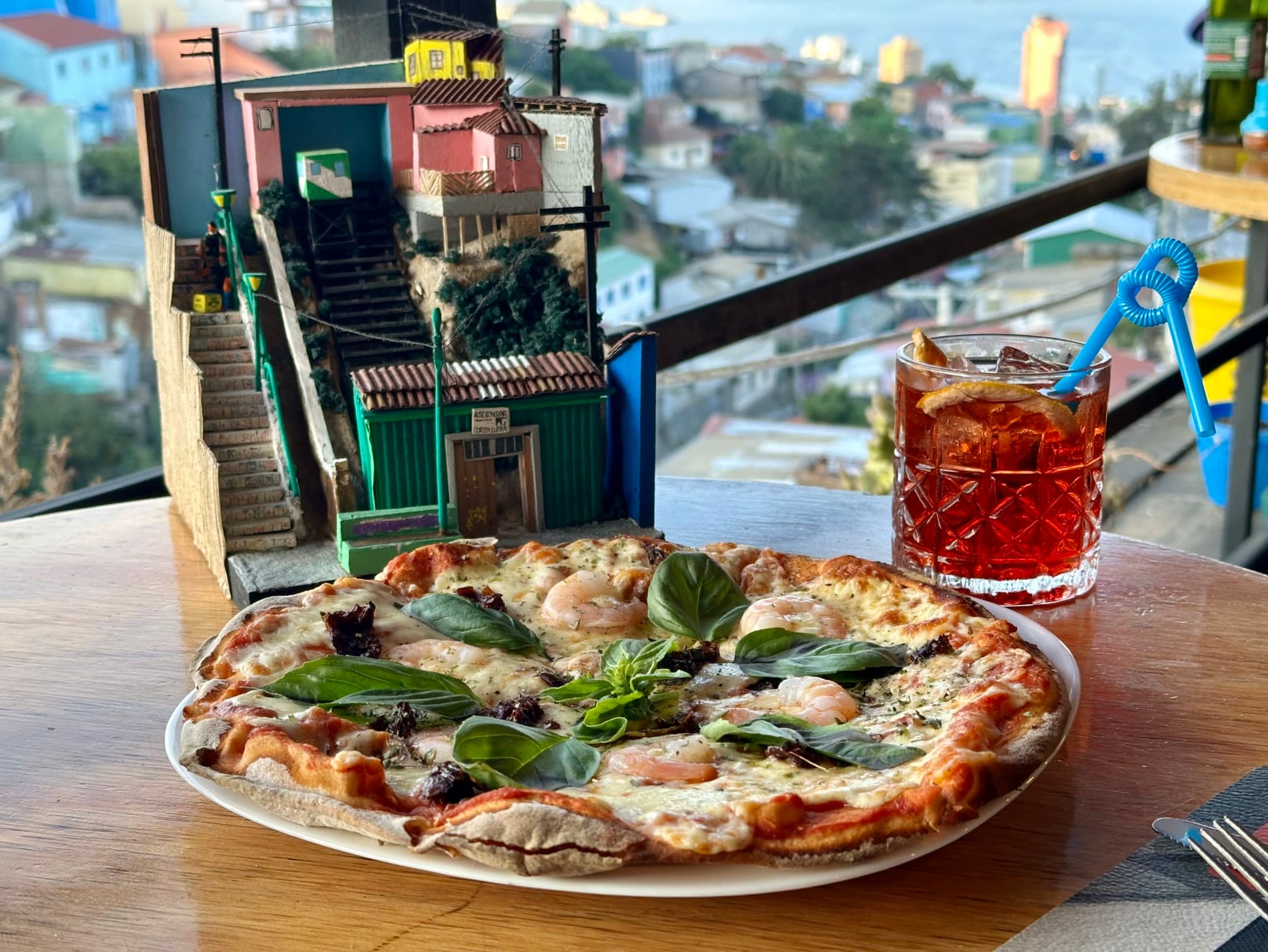 Pizza servida en una mesa con vista al ascensor y al puerto